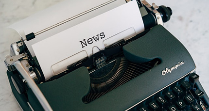 A typewriter with paper that says 'News'