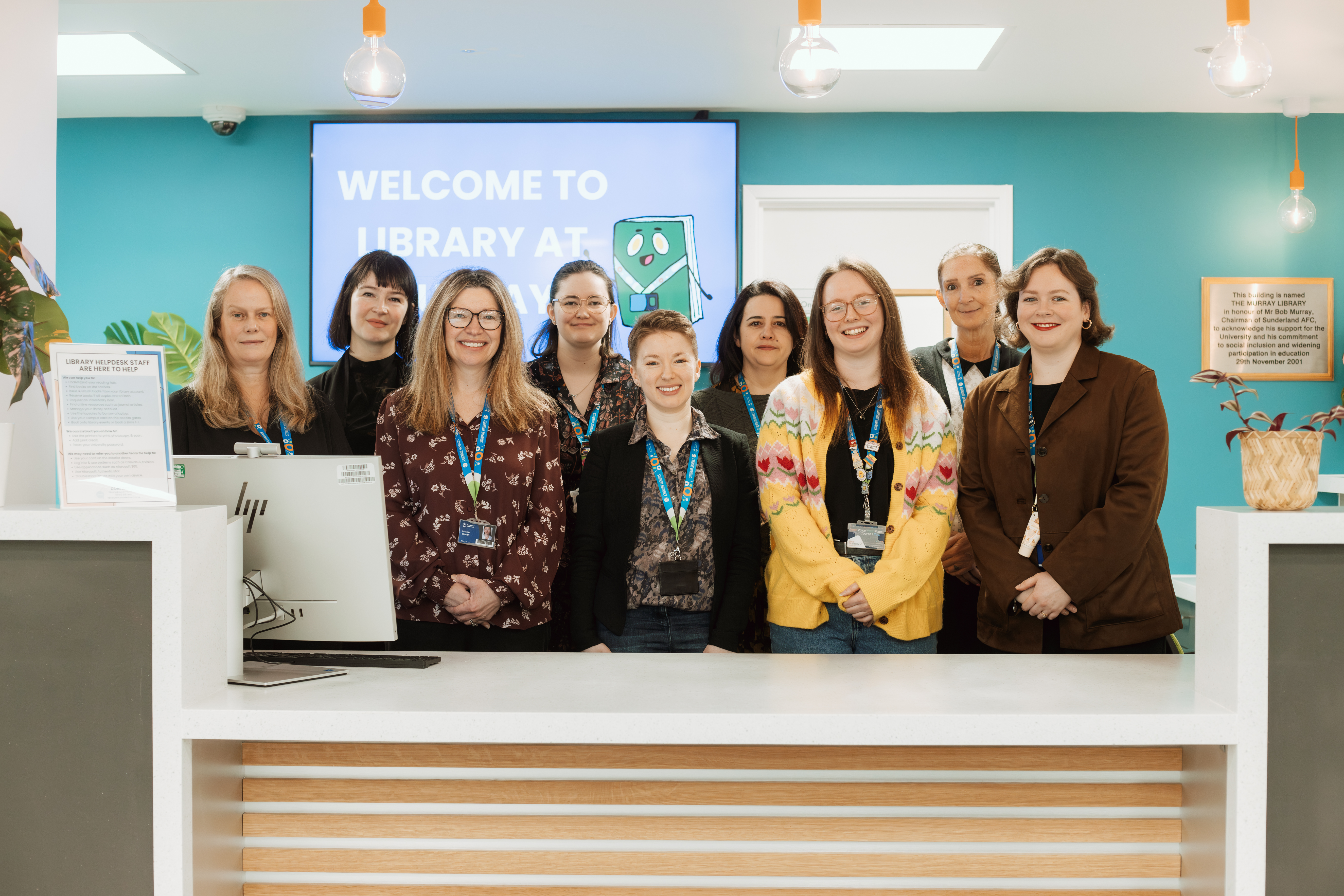 Photo of the nine members of the Library team smiling at the camera.