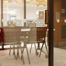 Close up view of table and chairs within group study pod with fire exit in background.