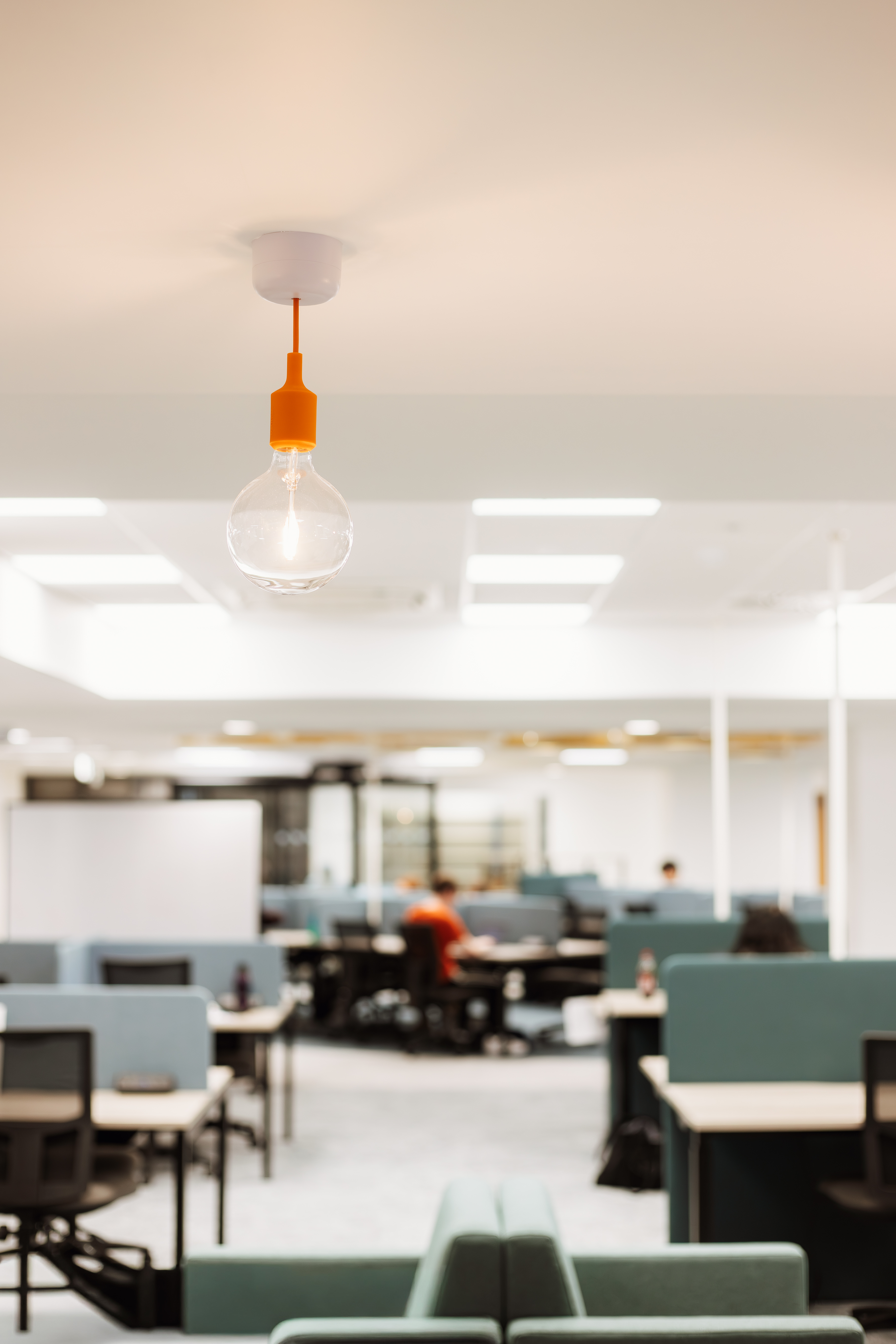 Decorative light in the foreground with view of study spaces in the background slightly blurred.