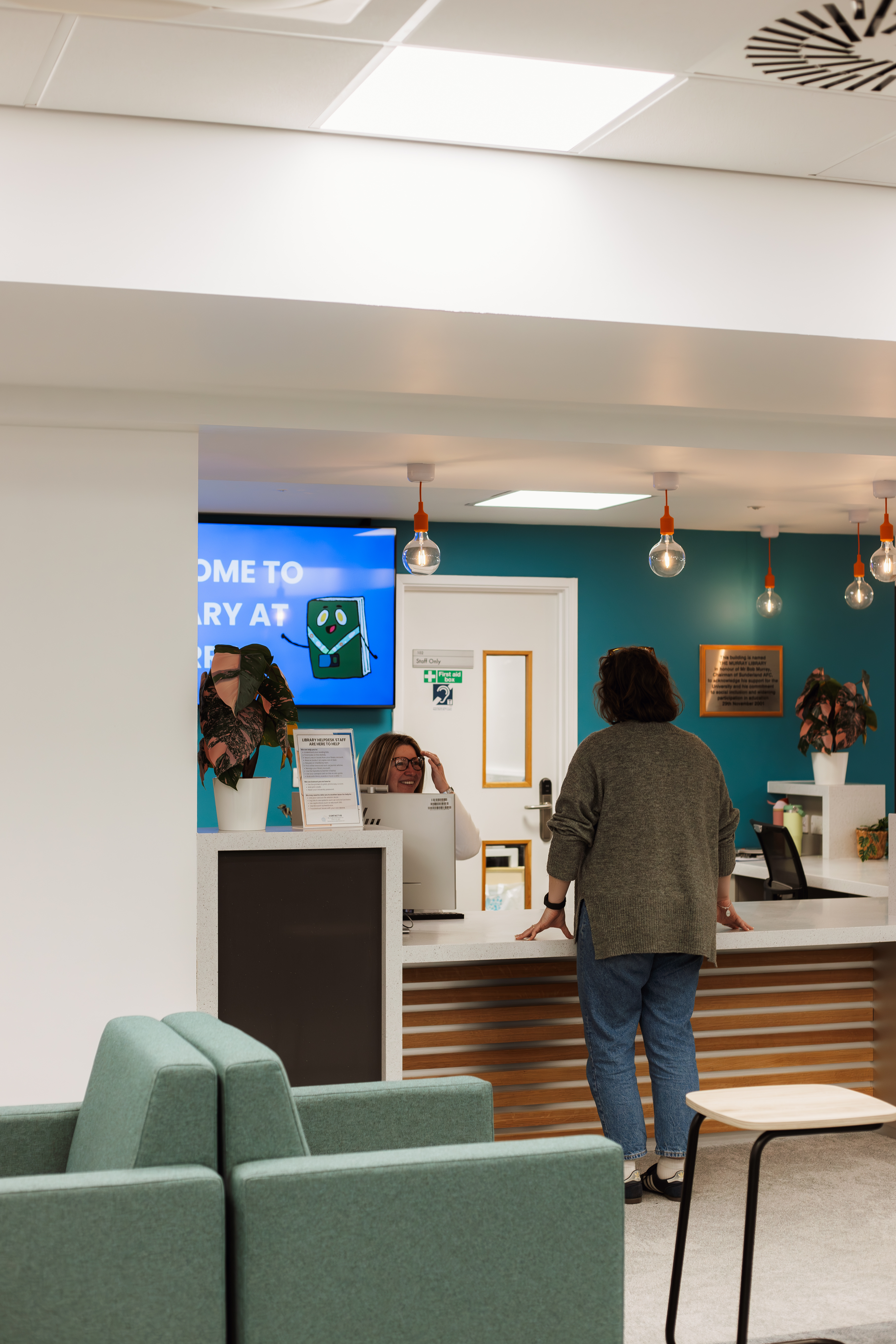 Staff member helping a student at the helpdesk.