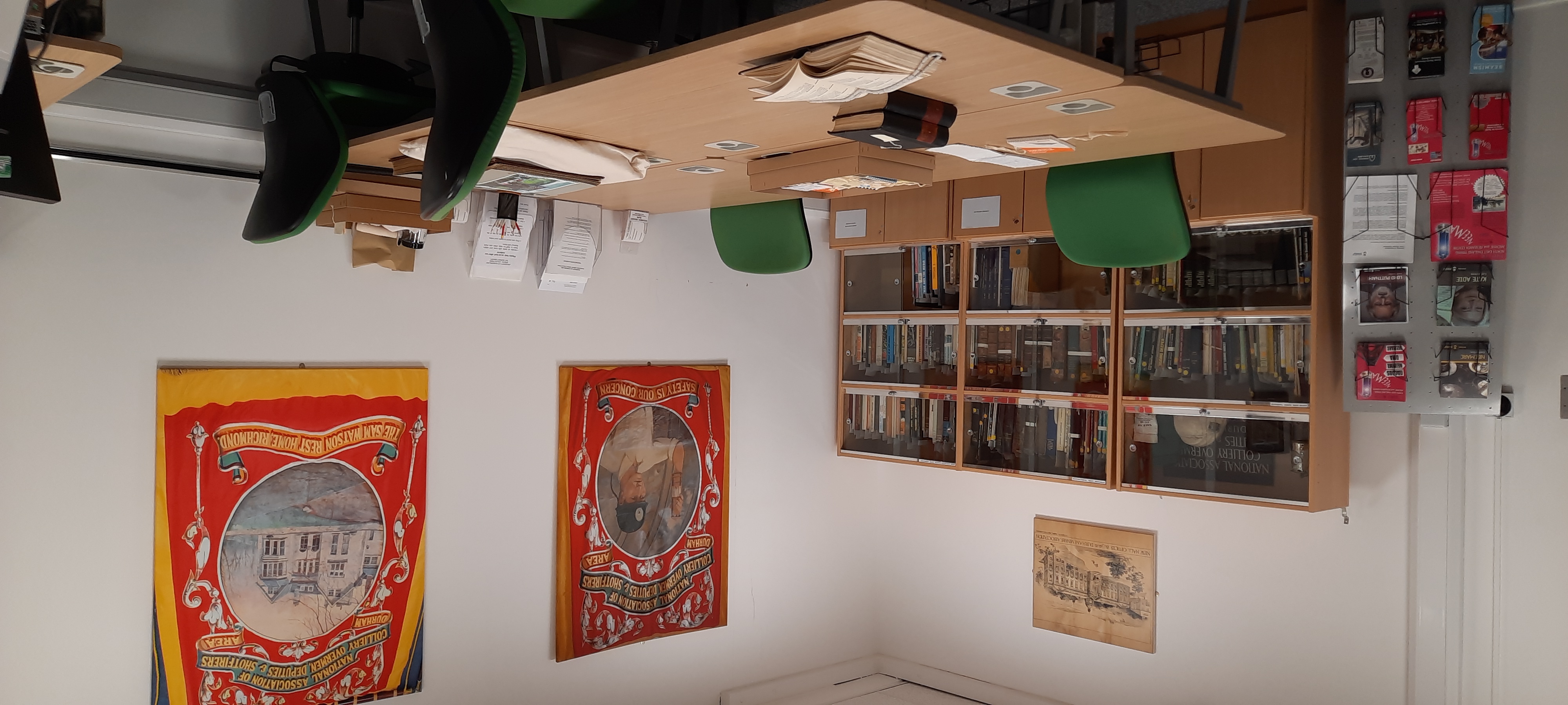 Room with table and chairs and replica mining banners on the walls.