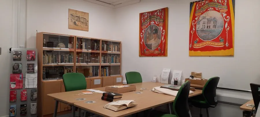 Room with table and chairs and replica mining banners on the walls.