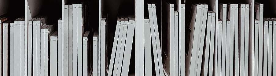 Row of books with white covers on a shelf